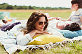 Family relaxing on blanket in sunny field