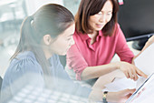 Businesswomen discussing paperwork