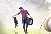 Man with saddle walking with jumping dog