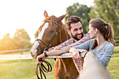 Couple with horse talking fence