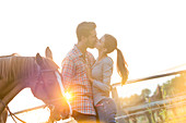 Couple kissing next to horse
