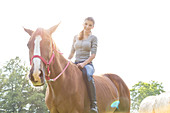 Smiling woman riding horse bareback