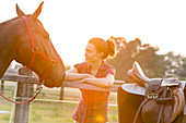 Woman looking at horse fence