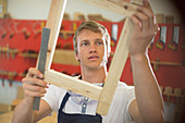 Carpenter examining wood in workshop