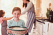 Smiling girl baking holding bowl of flour