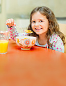 Smiling girl eating cereal
