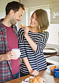 Girlfriend feeding boyfriend croissant