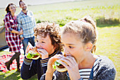 Brother and sister eating hamburgers