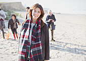 Woman in plaid scarf with family on beach