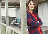 Pensive woman in sweater on porch