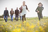 Brother and sister running in meadow