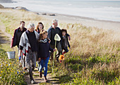 Family with nets and bucket on beach path