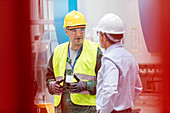 Engineer and worker talking in factory