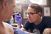 Tattoo artist preparing tattoo gun