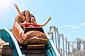 Friends riding log amusement park ride