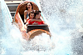 Friends on water log amusement park ride