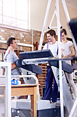 Physiotherapists helping man on treadmill