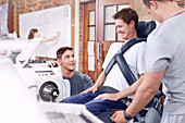 Physiotherapists guiding man at machinery