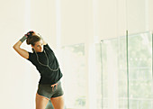 Fit woman stretching arm mirror