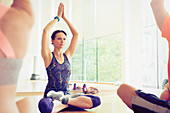 Woman with arms raised in exercise class