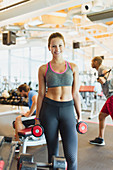 Woman holding dumbbells in gym