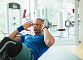 Focused man doing sit-ups at gym