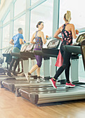 Man and women jogging on treadmills