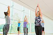 Yoga class with arms raised