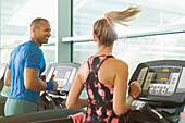 Man and woman on treadmills