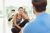 Smiling woman talking to man at gym