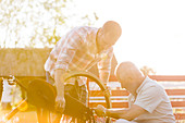 Father and adult son fixing bicycle