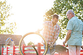 Father and adult son fixing bicycle