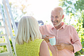 Senior couple drinking coffee outdoors