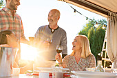 Family drinking wine at sunny patio table
