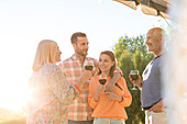 Family talking and drinking wine on patio