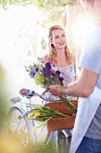 Florist placing flowers in bicycke basket