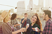 Young adult friends laughing and drinking