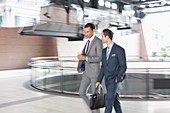 Businessmen with coffee walking