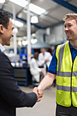 Smiling manager and worker handshaking