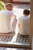 Father and son talking on front stoop