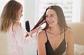 Daughter brushing mother's hair