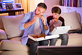 Father and son eating pizza