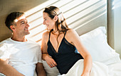 Smiling couple talking in bed