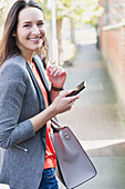 Businesswoman with cell phone on sidewalk