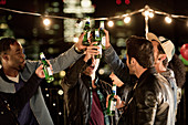 Young men toasting beer bottles