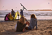 Women watching men preparing to kiteboard