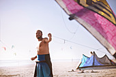 Smiling man pulling kiteboarding kite