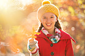 Girl holding golden autumn leaf