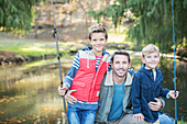 Father and sons with fishing rods