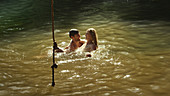 Young couple swimming in sunny lake